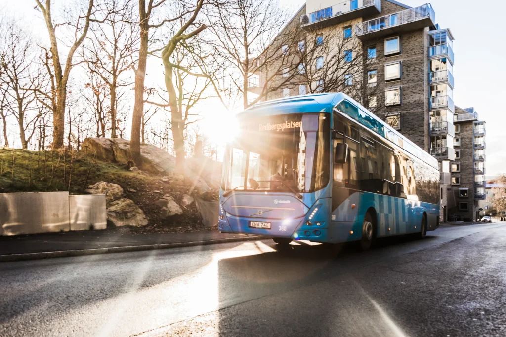 A Västtrafik bus drving towards Redbergsplatsen with sunlight right behind it.