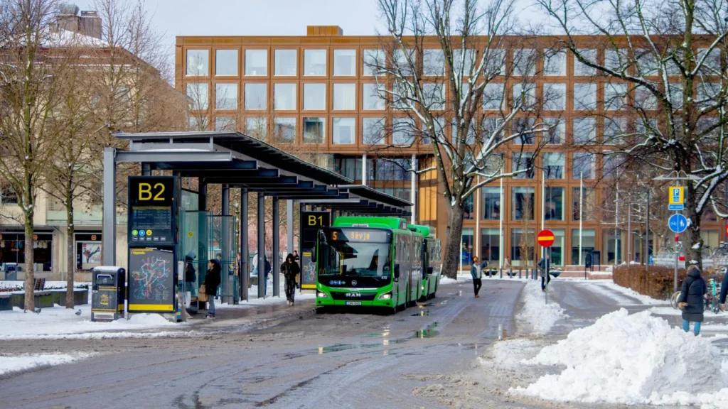 A bus from Gamla Uppsala Bus (GUB) driving on the streets of Uppsala during winter